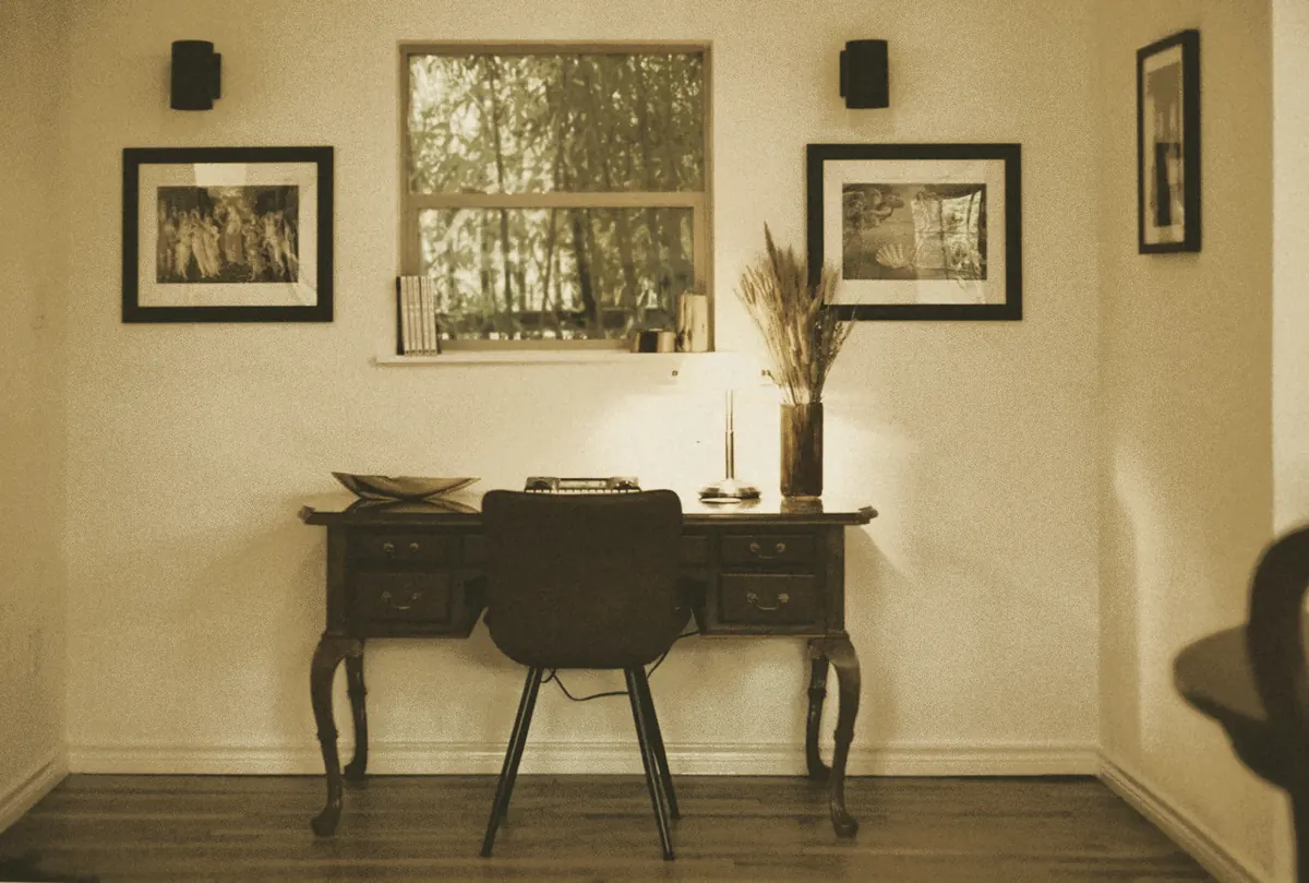 A writing desk beneath framed prints